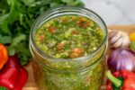 A vibrant jar of Dominican sofrito (sazón) made with fresh peppers, culantro, onions, garlic, and cilantro.
