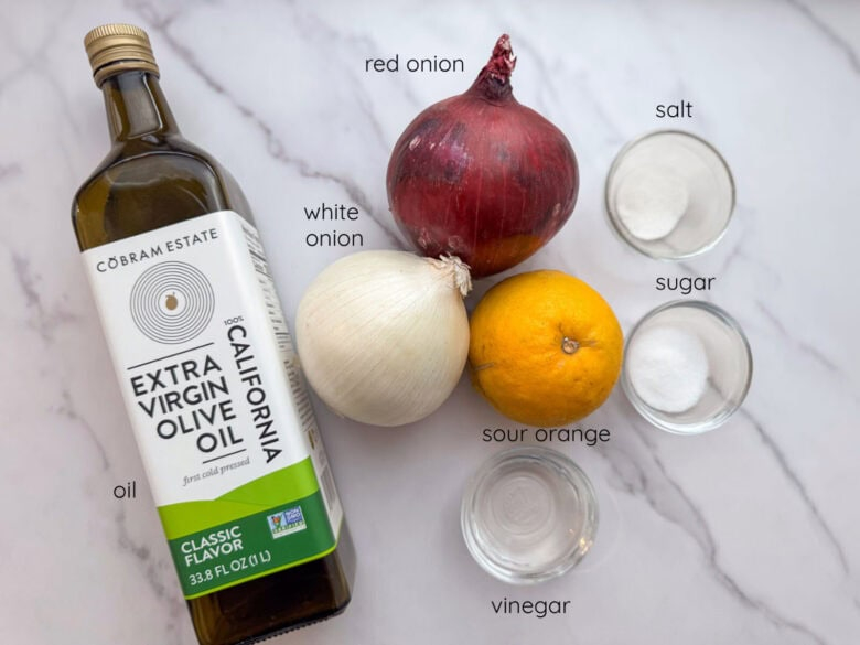 Ingredients for Dominican pickled onions including red onion, white onion, sour orange, extra virgin olive oil, salt, sugar, and vinegar