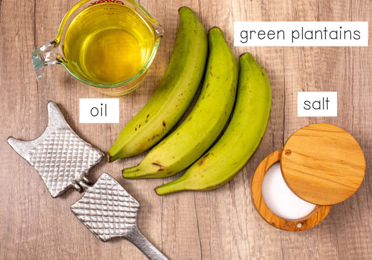 Dominican tostones ingredients including green plantains, canola oil, salt, and a traditional tostonera
