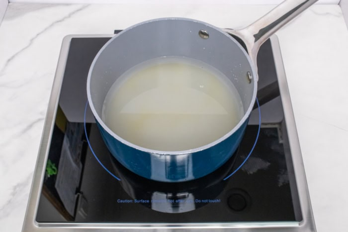 Sugar and water heating in a saucepan for homemade simple syrup