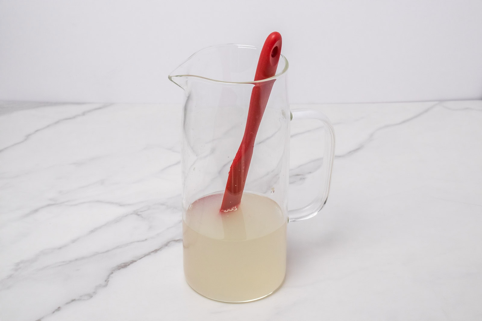Lime and water mixture in a glass pitcher for Morir Soñando de Limón.
