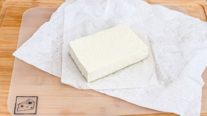 Block of queso de freír resting on paper towels before slicing